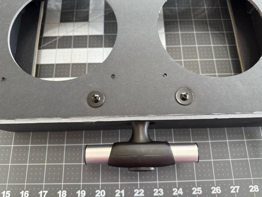 Installing the luggage handle with washers and screws visible on the outside. Ignore the filter flange for now—you'll install it later.