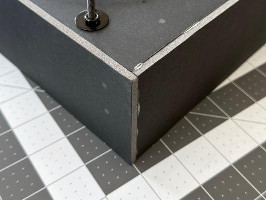 The three screw holes for a wheel marked on the back and bottom of the air purifier.