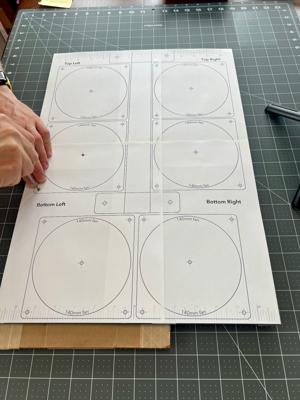 Using an awl to mark screw holes through the template on a rolling luggage style build.